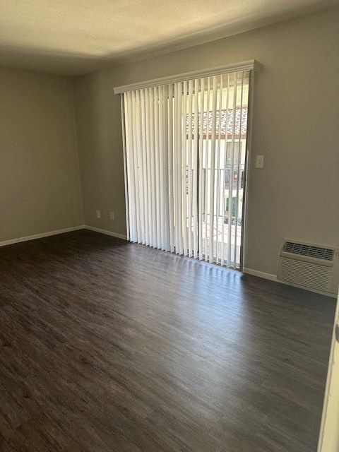 an empty living room with wood floors and a sliding glass door