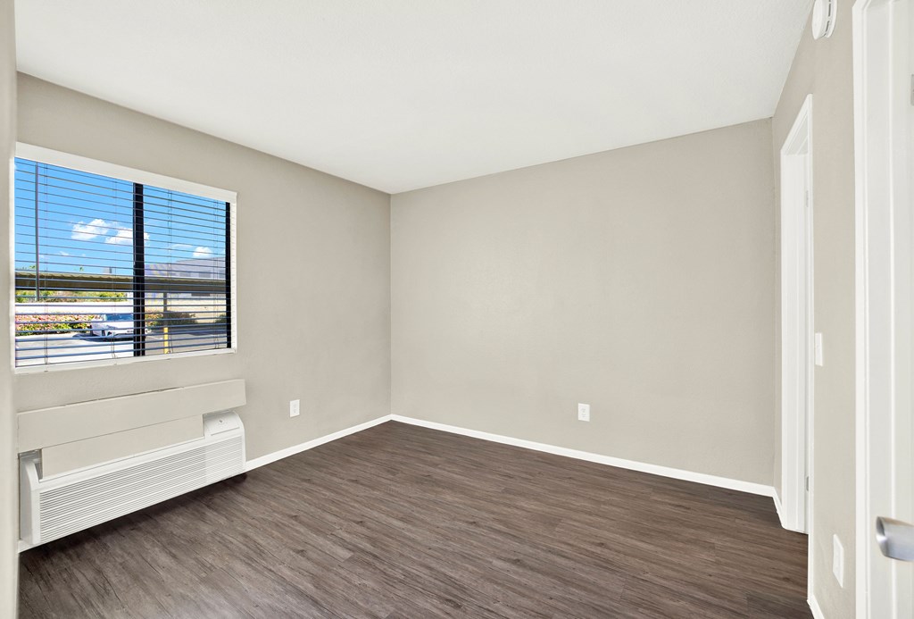 A room with a window overlooking a highway.