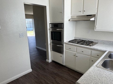 an empty kitchen with a stove and a sink