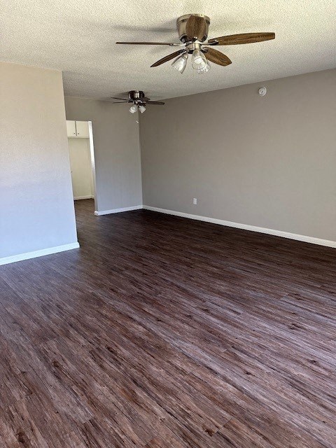 an empty living room with a ceiling fan