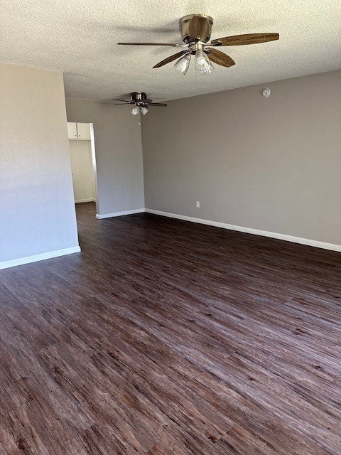 an empty living room with a ceiling fan