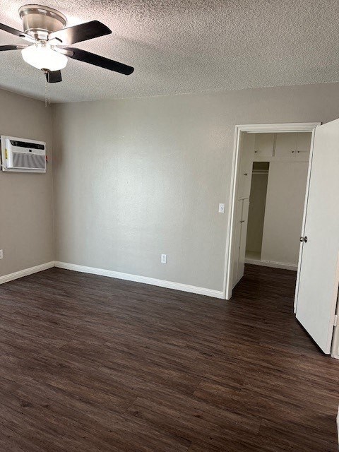 an empty living room with wood floors and a ceiling fan
