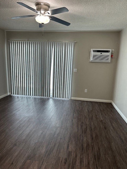 an empty living room with wood floors and a ceiling fan