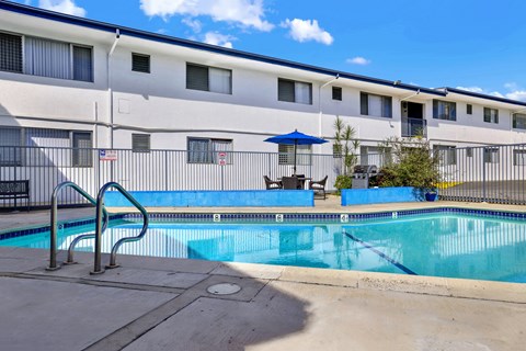 A swimming pool in front of a building with a flag on it.