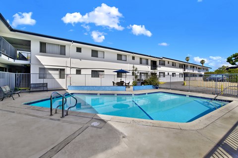 A swimming pool is located in front of a building.