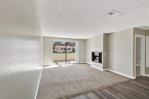 A living room with a fireplace and a carpet on the floor.