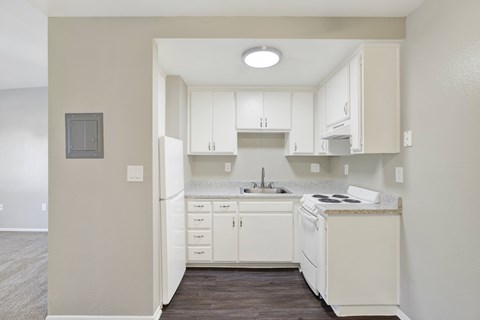 A kitchen with white cabinets and appliances.