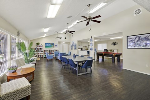 A room with a ceiling fan and a dining table with chairs.