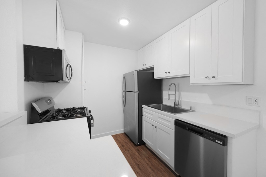 a kitchen with white cabinetry and black appliances