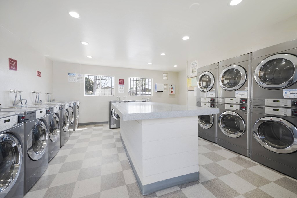 a laundry room with stainless steel washers and dryers
