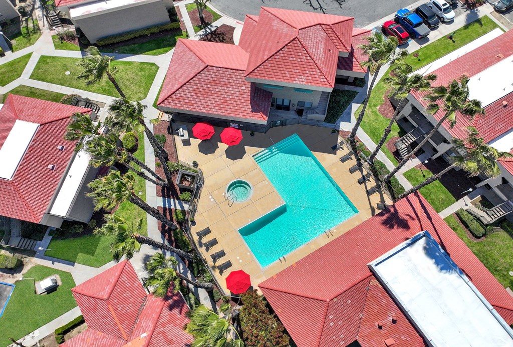 A red roofed house with a swimming pool in the backyard.