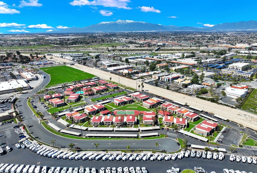 A large parking lot is in the foreground of a cityscape.