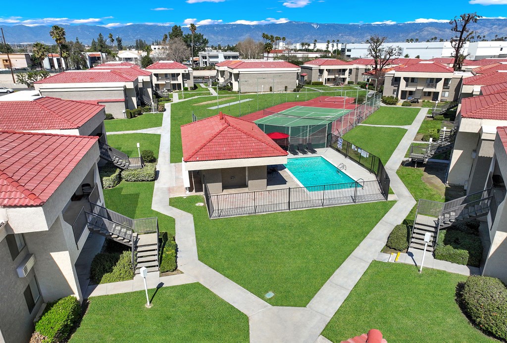 A view of a courtyard with a tennis court and a pool.