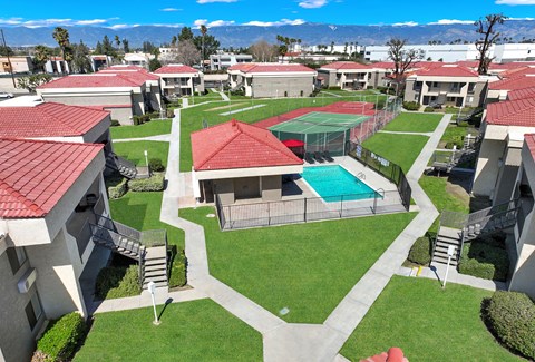 Aerial view of courtyard with pool and tennis court at CENTREPOINTE Apartments, Colton, CA