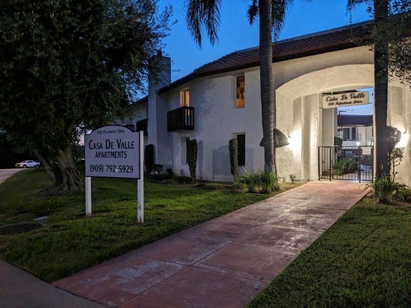 a sign in front of a house with a sign on the sidewalk