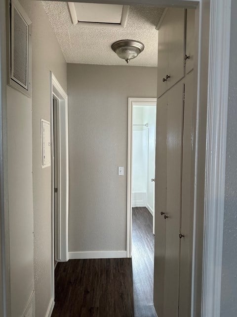 an empty hallway with a closet and a ceiling fan