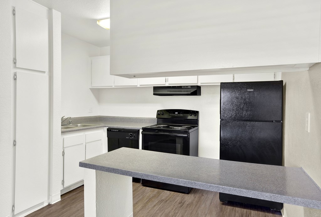 A modern kitchen with black appliances and white cabinets.