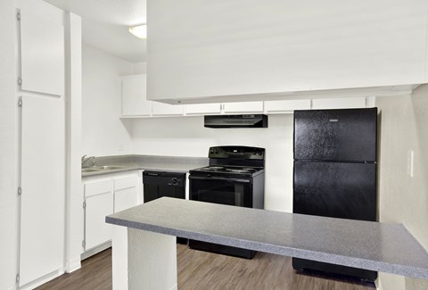 A modern kitchen with black appliances and white cabinets.