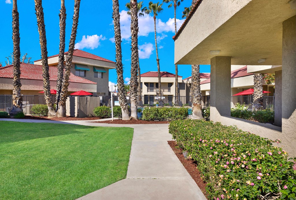 A building with a red roof and palm trees in front.