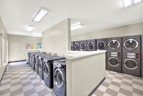 Modern laundry room with stacked washer dryer units at CENTREPOINTE Apartments, California