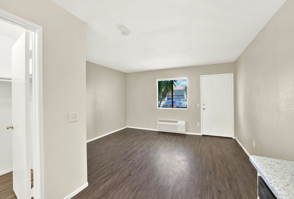 A room with a window and a picture on the wall.