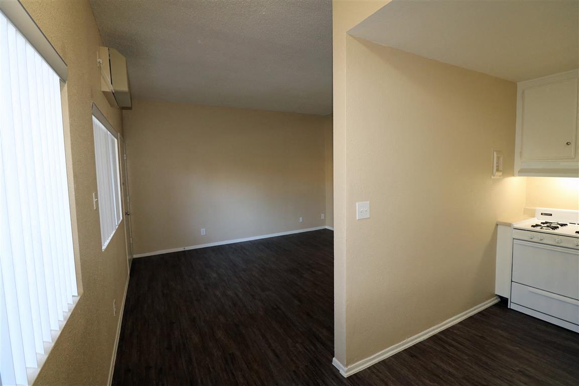 an empty kitchen and living room with a stove