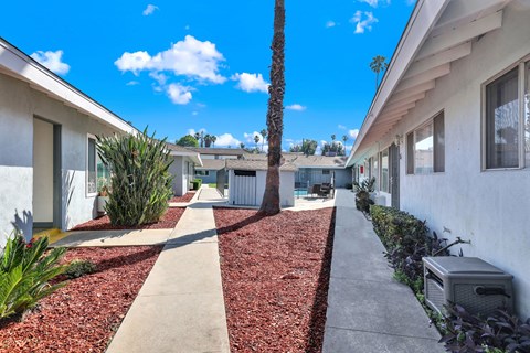 A white building with a red mulch pathway in front.