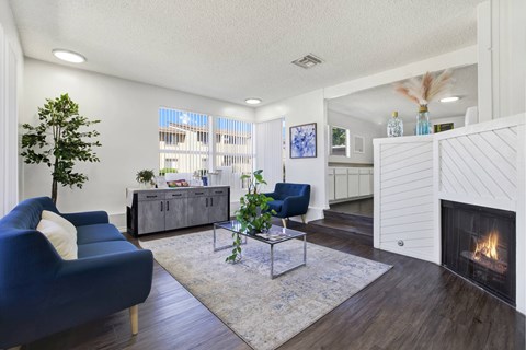 A living room with a blue chair and a fireplace.