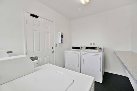 A white bathroom with a washing machine and dryer.