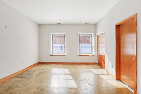Living room in Printers Square Unit 311 with large windows and wood flooring.