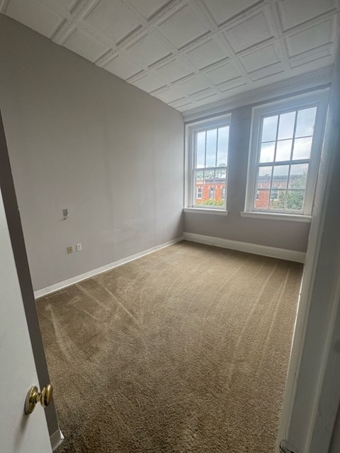 Representative Peabody Unit 304 bedroom with two windows and carpet.