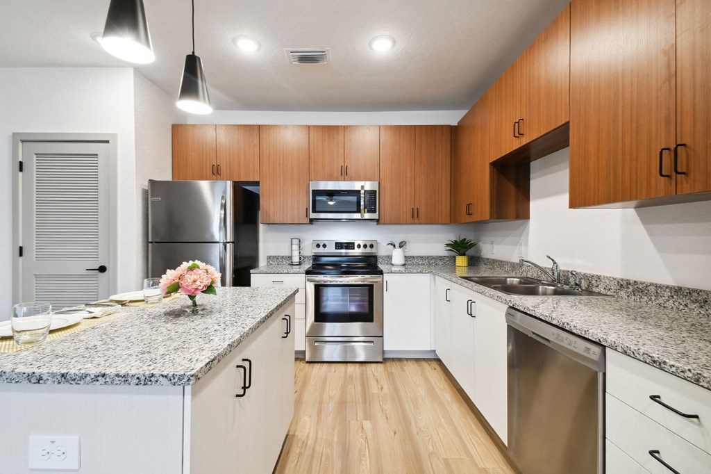 a modern kitchen with granite counter tops and stainless steel appliances at Gibson Oaks, Lakeland, 33809