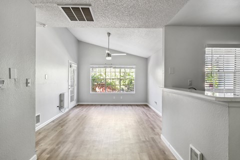 A spacious room with a window overlooking a garden.