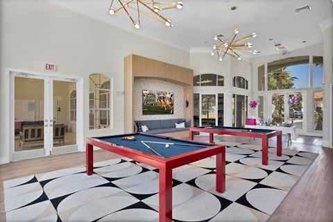 a game room with two ping pong tables and a television