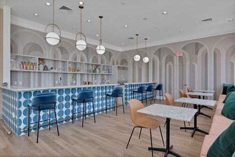 a Clubhouse with blue and white tables and chairs and a bar