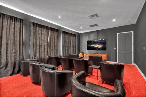 a large screening room with leather chairs and a television