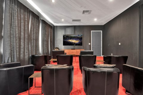 a conference room with leather chairs and a table with a television on the wall
