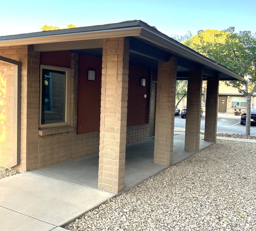 A small building with a red door and a brown roof.