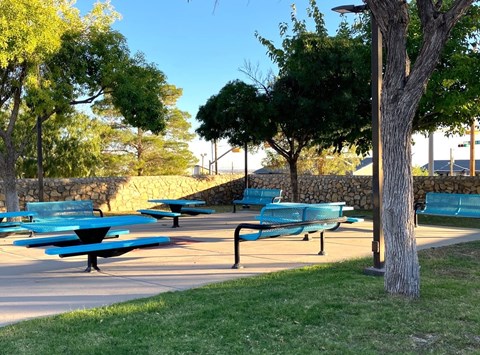 A park with blue benches and trees.