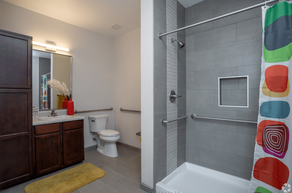 A bathroom with a toilet, sink, and shower.