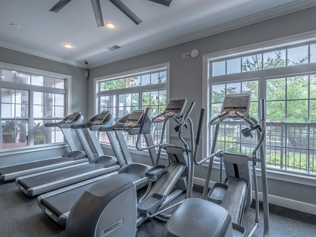 A gym with treadmills and a fan.