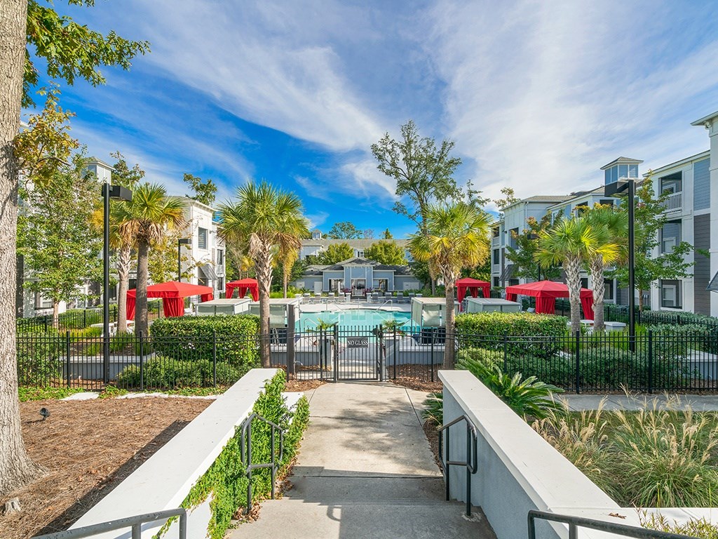 A pool area with a fence and a bench in front of a building.