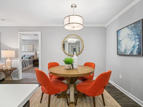 A dining room with a round table and chairs.