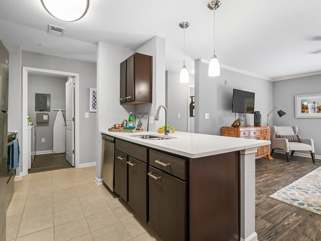 A modern kitchen with dark brown cabinets and a white countertop.