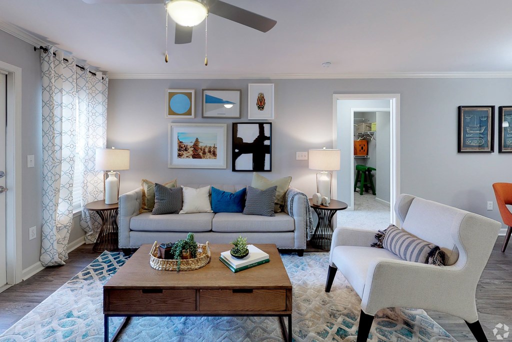 A living room with a white couch, a wooden coffee table, and a ceiling fan.