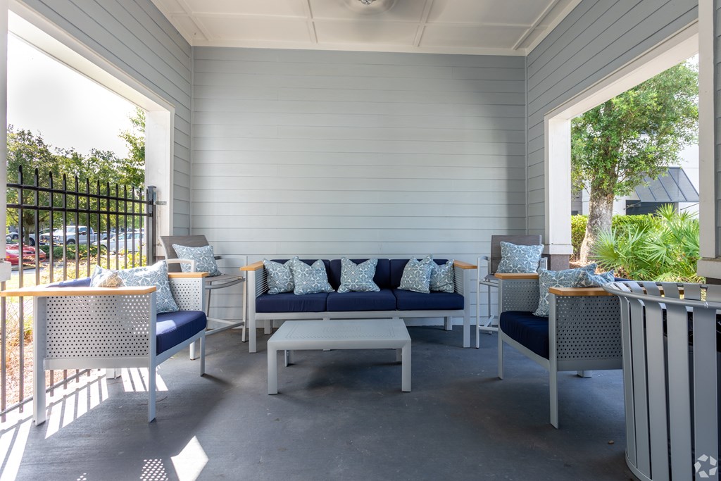 A white patio with a sofa and chairs.