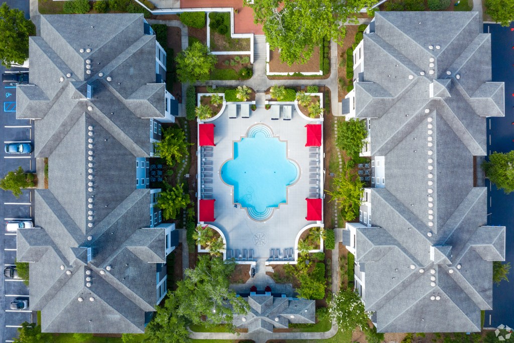A bird's eye view of a residential area with houses and a swimming pool.