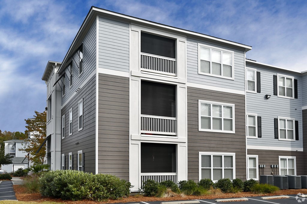 A modern two-story apartment building with balconies and multiple windows.