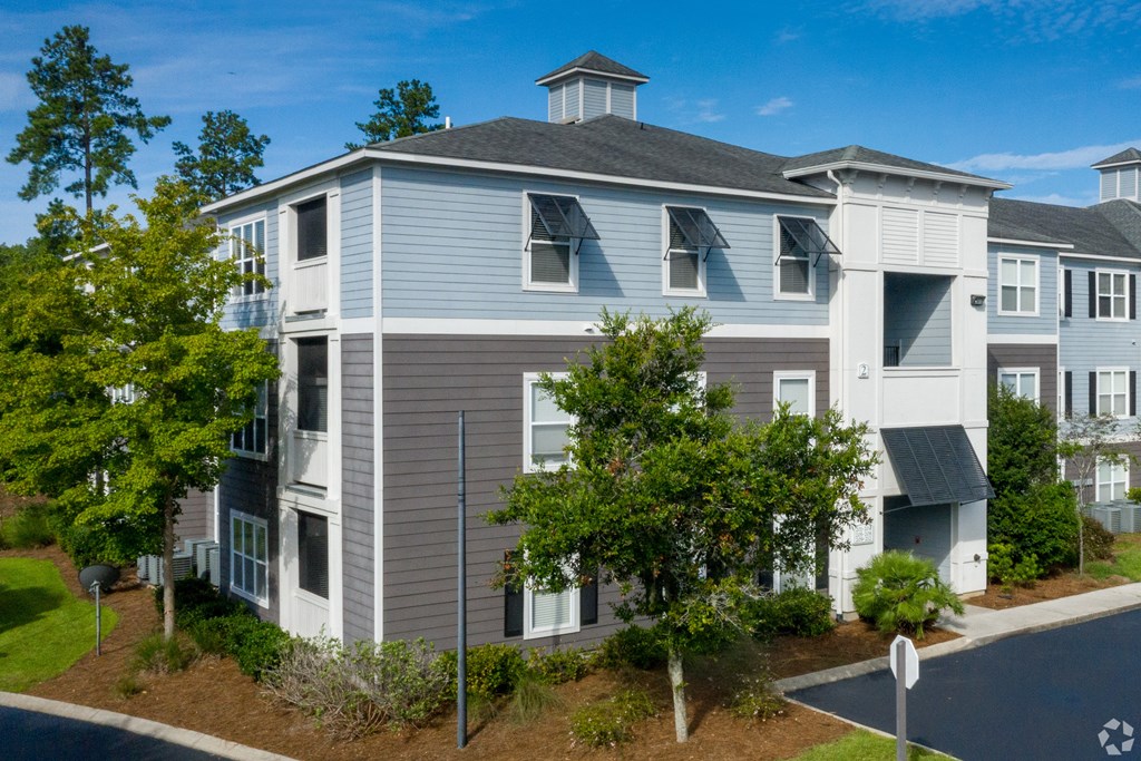 A modern apartment building with a mix of grey and white exterior.