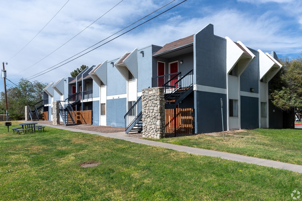 A modern house with a red door and a stone staircase.